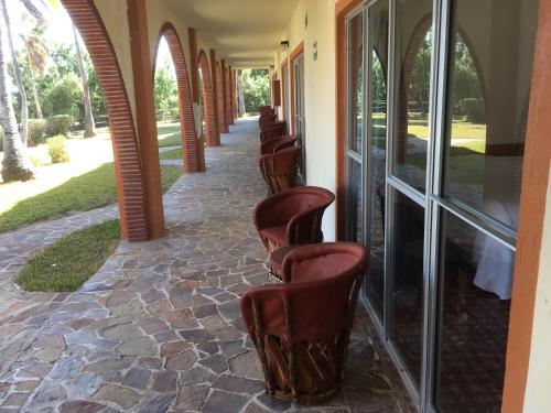 a row of chairs sitting on a walkway at Hotel Rancho Buenavista in Los Barriles
