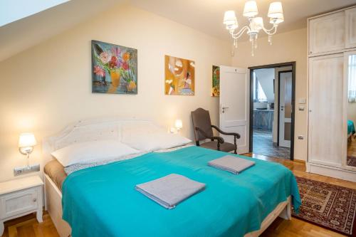 a bedroom with a bed with a blue blanket at Kiss-Henézi Guest House in Keszthely