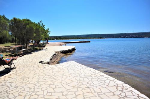 a person sitting in a chair next to a body of water at Apartmani Zora in Kruševo