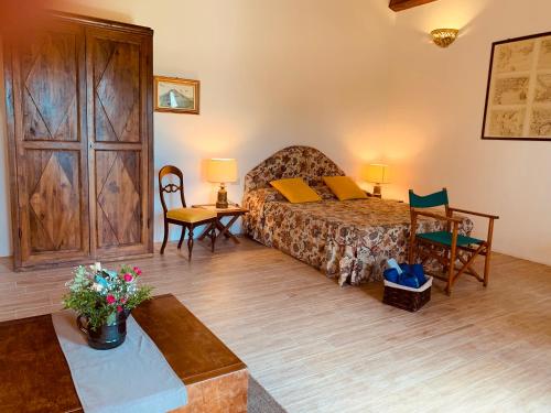 1 dormitorio con 1 cama, mesa y sillas en Olivandro en Casale Modica