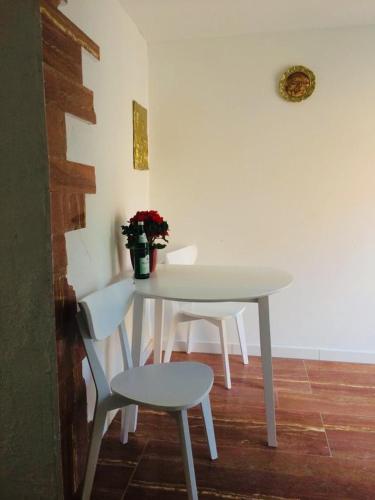 a white table with two chairs and a vase of flowers at Natur und Neckarblick bei Heidelberg in Hirschhorn