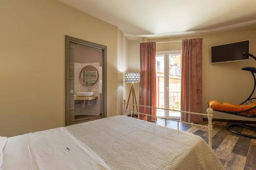 a bedroom with a bed and a television and a bathroom at BnB Sant'Alfonso in Agrigento