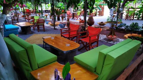 菲利亞特拉的住宿－茂斯9號公寓，餐厅设有绿色和红色的椅子和桌子