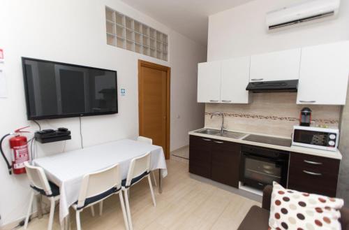 a small kitchen with a white table and a white counter at San Pietro Home in Rome