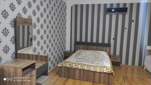 a bedroom with a bed and a wooden floor at Qabala Villa House Samir in Gabala