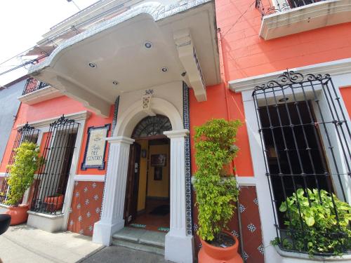 un edificio arancione con una porta e delle piante di Hotel Suites Del Centro a Città di Oaxaca
