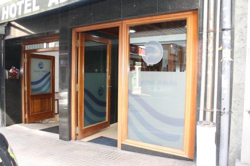 a store front with two glass doors on a building at Hostal Adelia in A Coruña