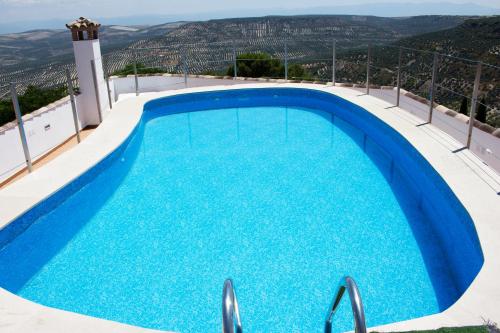 a swimming pool with blue water on top of a building at Hotel Rural Molino del Albaicín in Sabiote