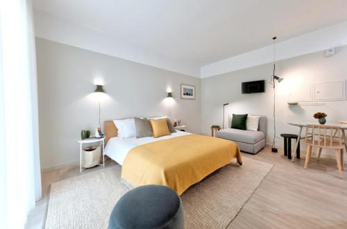 a bedroom with a bed and a table and a chair at Art Home Apartments in Aveiro