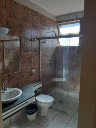 a bathroom with a toilet and a sink and a shower at Hotel Nautico in Três Marias