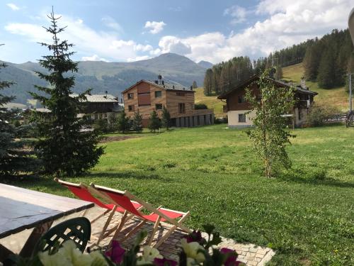 a yard with a table and chairs and a house at Chalet Barbara in Livigno