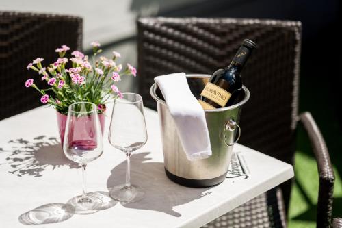 a bottle of wine in a bucket on a table with glasses at Horský Hotel Jelínek in Bedřichov
