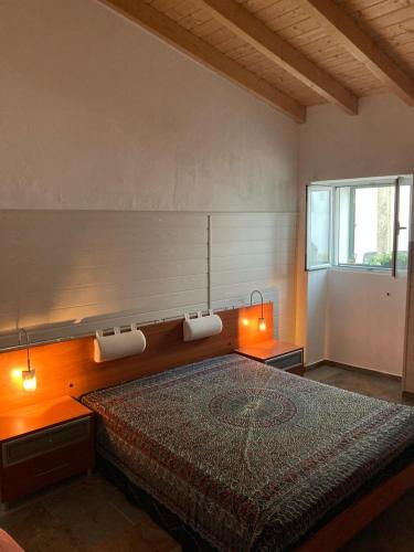 a bedroom with a bed with two lights on it at Casa do Correio in Odeleite