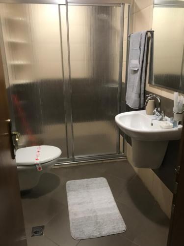 a bathroom with a shower and a toilet and a sink at Apartament Sunny, Варна- център in Varna City