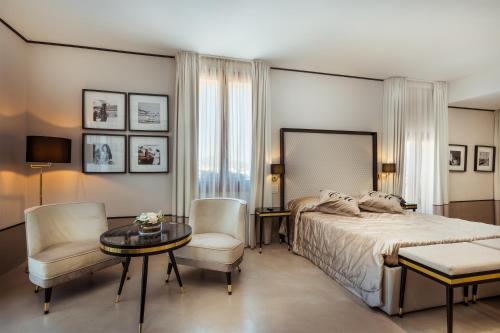 une chambre avec un lit, une table et des chaises dans l'établissement La Locanda Del Conte Mameli, à Olbia