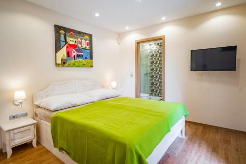 a bedroom with a bed and a flat screen tv at Kiss-Henézi Guest House in Keszthely