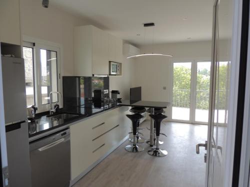 a kitchen with white cabinets and black counter tops at Apartamento Amarante - Vista São Gonçalo in Amarante