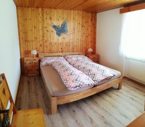 グレヘンにあるChalet Hedy Ferienwohnungのベッドルーム1室(壁に蝶が描かれたベッド1台付)