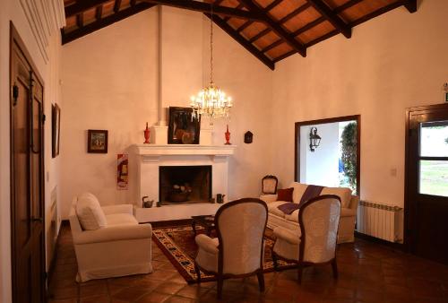 sala de estar con mesa, sillas y chimenea en Posada de los Poetas Hotel Boutique en San Lorenzo