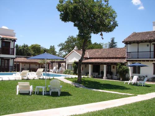 a yard with chairs and a pool and a house at Posada de los Poetas Hotel Boutique in San Lorenzo