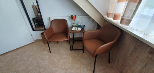 two chairs and a table in a small room at B&B Knooppunt70 in Arcen