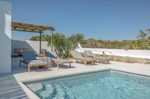 a patio with chairs and a swimming pool at Sea & Olives Suites Hotel and Villas in Plaka