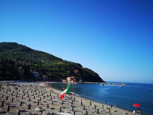 a beach with a bunch of umbrellas and the ocean at Elegant and Sea View Excelsior Apartment in Levanto