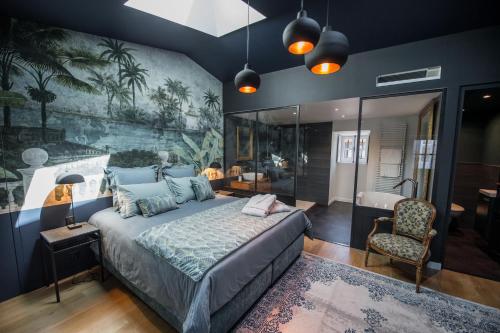 a bedroom with a large bed and a bathroom at Domaine de Chalaniat in La Sauvetat
