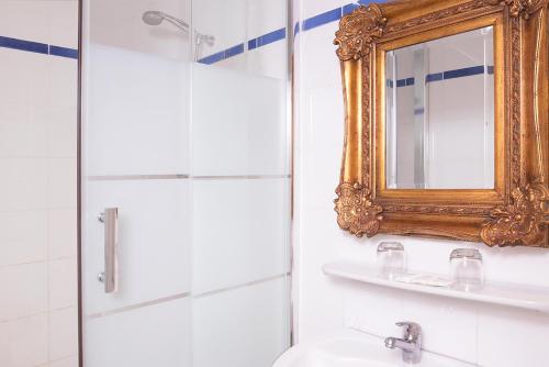 a bathroom with a mirror and a sink at Zazie Hôtel in Paris