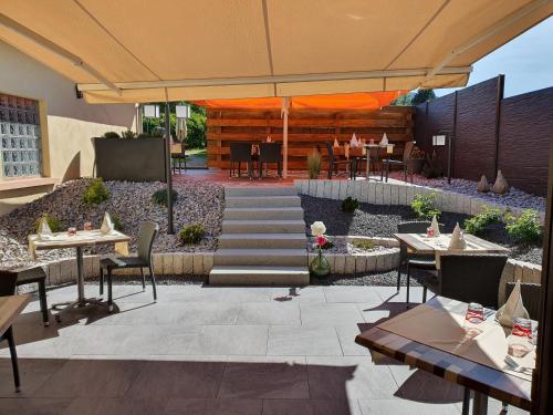 an outdoor patio with tables and chairs and an umbrella at Maison de Laveline in Laveline