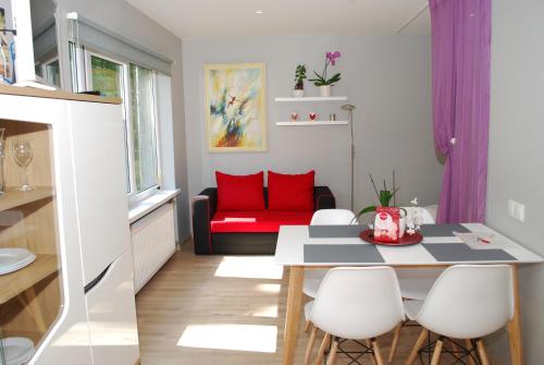 sala de estar con mesa y sofá rojo en Phoenix apartment, en Jūrmala