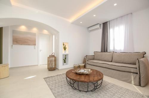 a living room with a couch and a coffee table at Sea & Olives Suites Hotel and Villas in Plaka