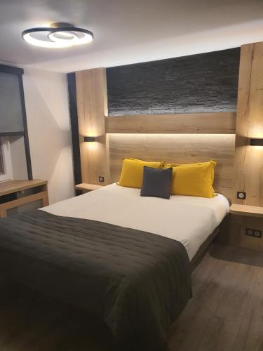 um quarto com uma cama grande e almofadas amarelas em Maison de Laveline em Laveline