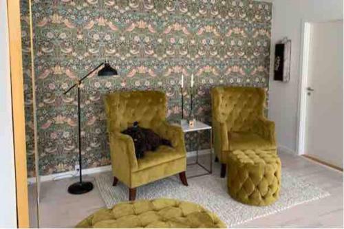 a living room with two chairs and a lamp at Lejlighed på Torvet i Stege in Stege