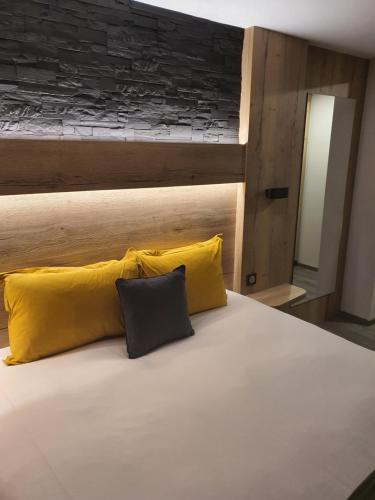 a bed with two yellow pillows on top of it at Maison de Laveline in Laveline
