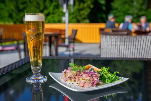 a plate of food and a glass of beer at Waldhotel Vogtland in Klingenthal