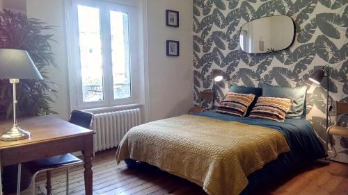une chambre avec un lit, une table et un miroir dans l'établissement Les Appartements du 31 - Centre Ville - 1er étage - 56 m2, à Quimper