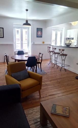 ein Wohnzimmer mit einem Sofa und einem Tisch in der Unterkunft Les Appartements du 31 - Centre Ville - 1er étage - 56 m2 in Quimper