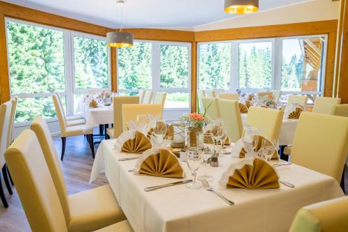 a dining room with white tables and yellow chairs at Waldhotel Vogtland in Klingenthal