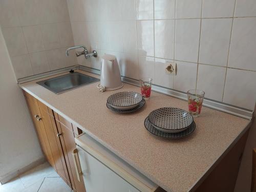 a kitchen counter with two plates and a sink at Avli Studios in Kokkino Nero