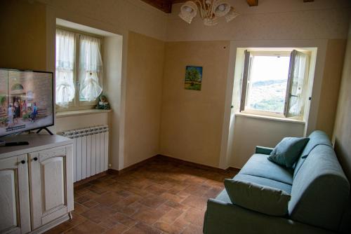 a living room with a blue couch and a television at La Beppa - Casa Vacanza in Pontremoli