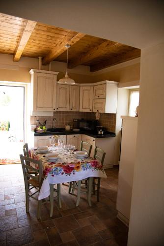 a kitchen with a table with chairs and a table cloth at La Beppa - Casa Vacanza in Pontremoli