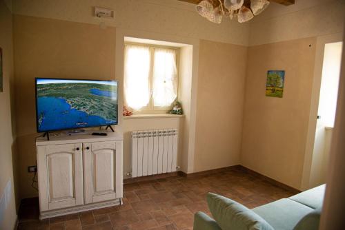 a living room with a flat screen tv on a cabinet at La Beppa - Casa Vacanza in Pontremoli
