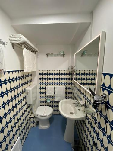a blue and white bathroom with a toilet and a sink at SUITE 4 CANTI in Palermo