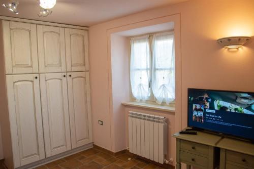 a living room with a tv and a window at La Beppa - Casa Vacanza in Pontremoli