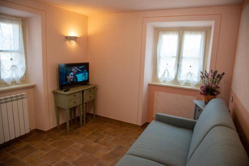 a living room with a couch and a television at La Beppa - Casa Vacanza in Pontremoli