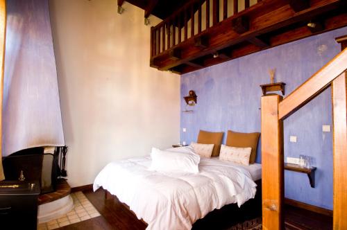 Bett in einem Zimmer mit blauer Wand in der Unterkunft Mansion of Kerkini in Kerkíni