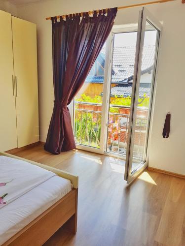 a bedroom with a bed and a large window at Apartman Lukić in Korenica