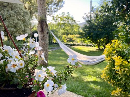 a hammock in a garden with flowers at Il cielo in una stanza in Itri