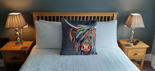 a bed with a pillow with a cow on it at Scotia House - Beautifully Presented Accommodation in Harrogate